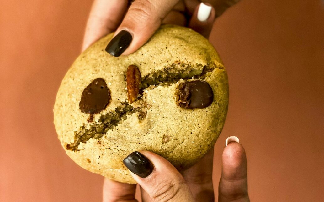a person holding a cookie with a smiley face on it